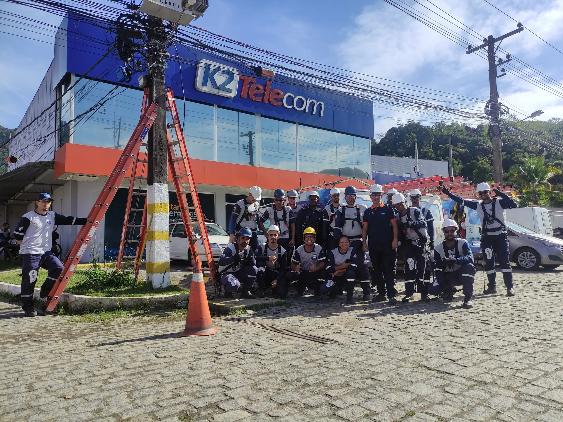 Equipe da K2 em frente à fachada da empresa
